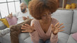 © Krakenimages.com - An interracial couple engages in a serious conversation in a modern living room, highlighting relationship dynamics.