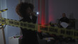 © Krakenimages.com - A woman and a man investigate a dimly lit indoor crime scene with caution tape and evidence markers.