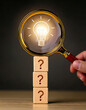 © anandart - Idea discovery and inquiry concept. Hand holding a magnifying glass over question marks with light bulb, symbolizing idea discovery. Problem solving, Creative thinking, Company find business solution