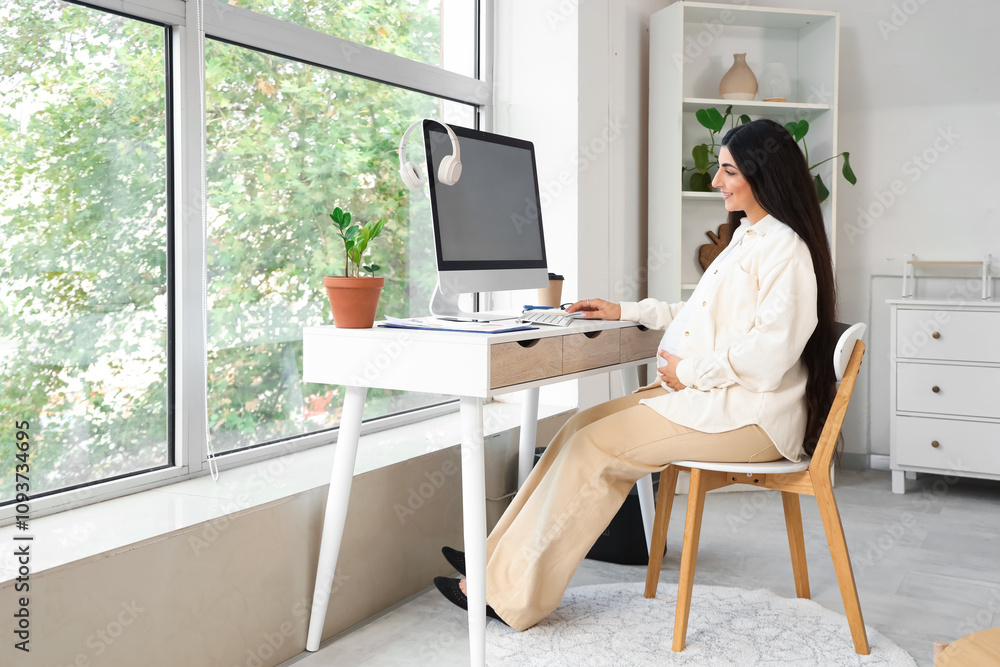 Pregnant businesswoman working with computer at home