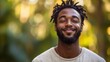 ©  Dreamy Shots - Smiling man standing in natural sunlight, exuding confidence and happiness, enjoying peaceful outdoor moment, positive emotions, glowing greenery background, relaxed lifestyle