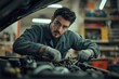 © gankevstock - Man automotive technician repairing a car engine in a professional garage environment