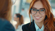 © ChimE - Confident woman in glasses smiles at the camera, showcasing professionalism in a modern office environment.