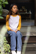 © Wavebreak Media - asian female teenager sitting on porch, wearing casual clothes, looking thoughtful and relaxed