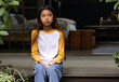 © Wavebreak Media - asian female teenager sitting on porch, wearing casual clothes, looking thoughtful at home