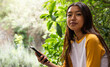 © Wavebreak Media - asian female teenager using smartphone outdoors, enjoying nature and relaxing in garden, copy space