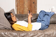 © Wavebreak Media - asian female teenager relaxing on couch at home, using smartphone, wearing casual clothes