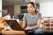 © JackF - Creative young female designer working with laptop in apartment under renovation, planning interior finishing and decoration