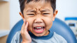 © Omri - Little Asian boy suffering from toothache. emotional Asian boy who is suffering. A sad child with a toothache. Dental problem.
