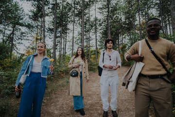 Poster - A diverse group of friends walking through a lush forest, enjoying nature, and bonding. They are relaxed and carrying flowers, capturing the essence of friendship and outdoor exploration.