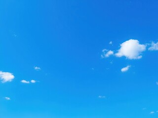 Wall Mural - Small blue dots scattered across a vast expanse of blue sky with some scattered white clouds, abstract, white clouds,