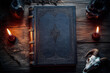 © Dmitriy - An ancient book of magical spells and a goat skull in the light of burning candles on a witch table background...