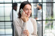 © Katsiaryna - Businesswoman with phone in modern office
