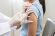 © KMPZZZ - Health care, corona virus, hand of woman nurse, doctor giving syringe vaccine, injection dose on arm sick patient at clinic. Vaccination, immunization disease prevention against flu pandemic influenza