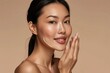 © Aleksandr - Beautiful Asian Woman Applying Moisturizer, Skincare Routine, Natural Beauty on Beige Background.