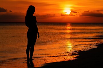 Wall Mural - silhouette of woman at sunset beach. perfect for depicting solitude, peace, or summer vacation theme