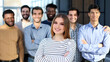 © Katsiaryna - young woman posing for the camera in front of her team in the office