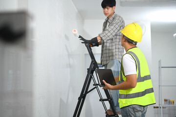 Painter and supervisor discussing work in a construction or renovation environment