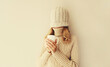 © rohappy - Happy funny young woman with cup of coffee drink in winter hat, sweater having fun on background