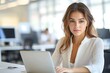 © hens - Professional businesswoman working at modern office desk with laptop focused expression in corporate setting