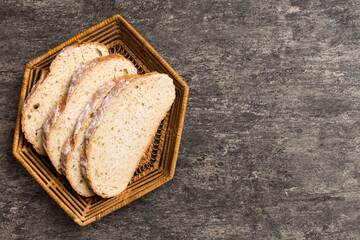 Wall Mural - Freshly baked bread slices on basket against natural background. top view Sliced bread