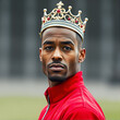 © Omri - Portrait of self-confident male in red jacket with crown on his head.