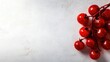 © Seyyar - Vibrant cluster of fresh red cherry tomatoes on a smooth white textured background, ideal for adding text or graphics.