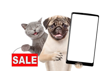 Poster - Smiling Pug puppy holds big smartphone with white blank screen in it paw, showing close to camera. Happy cat showing signboard with labeled 