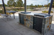 © Doublelee - Modern public barbecue station with a stone-clad base in an outdoor recreational area. Built-in electric grill facilities with concrete paving, metal seating in public park.
