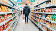 © Katewaree - Shopper Walking Through Grocery Store Aisle Surrounded by Colorful Packaging of Food Products and Household Items in a Modern Retail Environment
