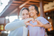 © Odua Images - mother and daughter making love hand sign with blurred background