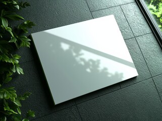 Aufkleber - A white vertical rectangle poster mockup, showcasing empty space and subtle hawthorn leaf shadows, against a light grey concrete wall. Flat lay, top view, 3D image.