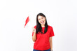 © Sino Images Studio - beautiful Asian woman smiles while proudly holding the Indonesian flag, set against a white background