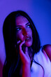 © FATIR29 - High Fashion model woman in colorful bright neon blue and purple lights posing in studio. Portrait of beautiful woman with trendy glowing make-up. Art design vivid style