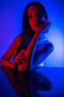 © FATIR29 - High Fashion model woman in colorful bright neon blue and purple lights posing in studio. Portrait of beautiful woman with trendy glowing make-up. Art design vivid style