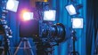 © Artajar - Professional Video Camera Setup with Multiple Lights on a Blue Background