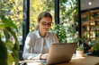 © Level UP - Focused Happy Professional Businesswoman Working on Laptop in Bright Modern Office Space with Natural Light, Smiling Female entrepreneur executive sitting at workplace background large windows