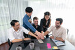 © InfiniteFlow - Group of diverse office worker join hand together in office room symbolize business synergy and strong productive teamwork in workplace. Cooperation and unity between business employee. Prudent