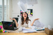 © Odua Images - A stressed woman in a cluttered home office is throwing papers into chaos all around her