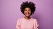 © Lednev - Girl with dark skin, a smile and a lush hairstyle in the middle of a purple background.