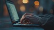 © GRYZZ - Closeup of hands typing on laptop with code on the screen.