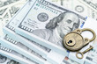© William W. Potter - Financial security, wealth protection, confidentiality, and safeguarding investment : Stacks of US dollar 100 bills with a padlock and key, symbolizing wealth management, savings, protection of assets