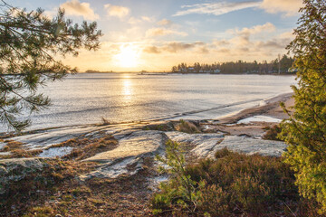 Wall Mural - Shore of a lake at sunrise. Landscape shot in the Narur in the morning. Forests lake and water at the beginning of winter or in autumn. Sweden, Scandinavia