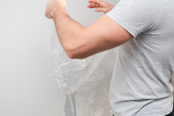 Man is standing in a room with a roll of protective foil on the floor