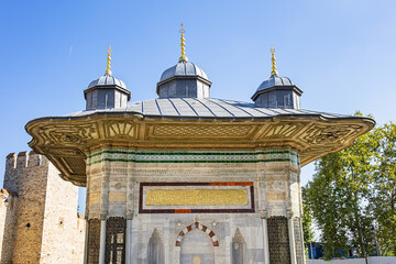 Marble fountain of Sultan Ahmed III (or Ahmet Cesmesi, 1728) Turkish rococo water fountain, located in Great Square in front of Imperial Gate of Topkapı Palace. Istanbul, Turkey.