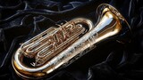 A gleaming euphonium instrument lying on a plush black velvet cloth its intricate engravings visible under a focused spotlight