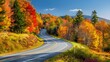© m.naeem - A scenic highway winding through vibrant autumn foliage in Vermont, USA, with colorful trees lining the road under a clear blue sky.