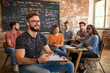 © Adamandgirls - A group of diverse young adults engaged in a collaborative discussion in a creative classroom setting.