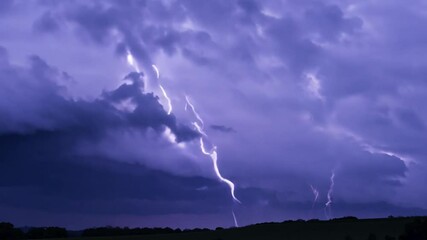 Aufkleber - A dramatic display of lightning cuts through dark storm clouds while illuminating a rural landscape at twilight. The intense atmosphere suggests an approaching storm.