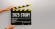 © noppadon - 2025 story. handwriting on film slate or movie clapboard. starting to new story. Happy new year film industry.